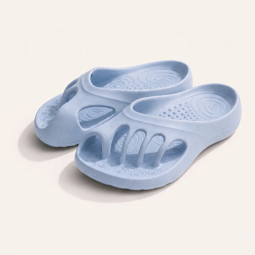 A pair of baby blue Roomtoes slides